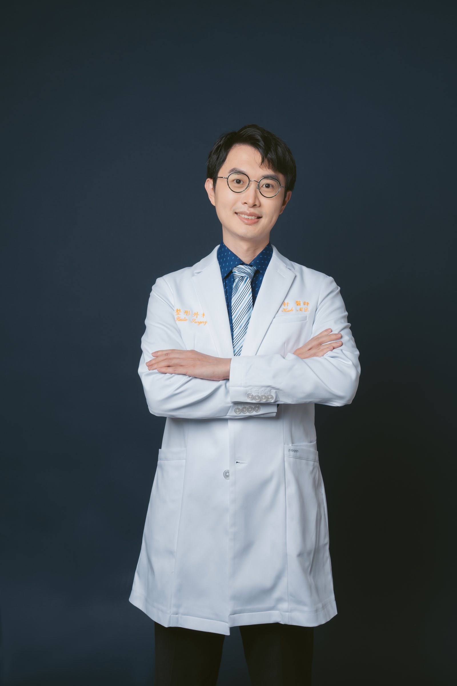 謝宇軒醫師身穿白袍、雙手抱胸